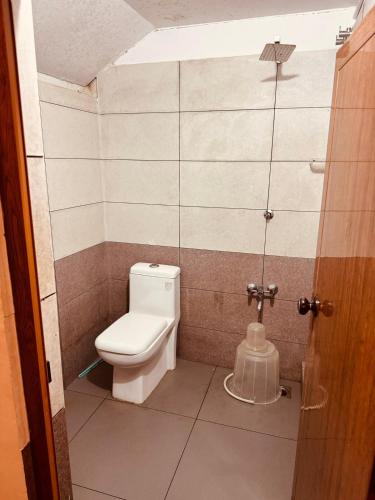a small bathroom with a toilet and a shower at Padmalayam Heritage Villa in Mānantoddy