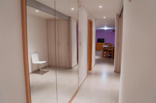a hallway with a mirror and a chair in a room at Apartaments Ca L'Albert in La Pobla de Segur