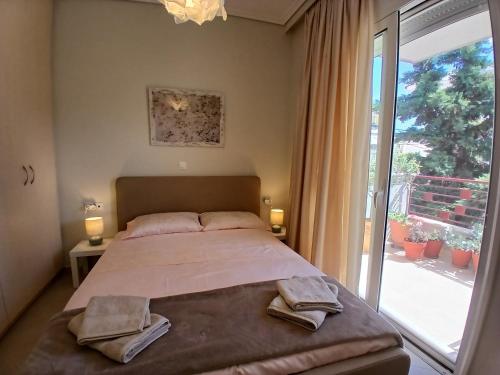 a bedroom with a bed and a large window at Anelia in Nea Artaki