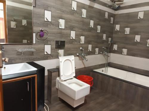 a bathroom with a toilet and a sink and a tub at FM Villa Auroville in Pondicherry