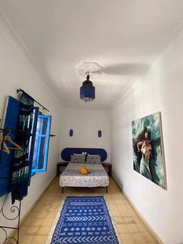 a room with a bed and a painting on the wall at Riad Safi - maison historique in Safi