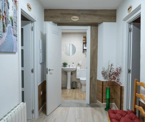 a bathroom with a white toilet and a sink at La Casita de Lucia in Trescasas