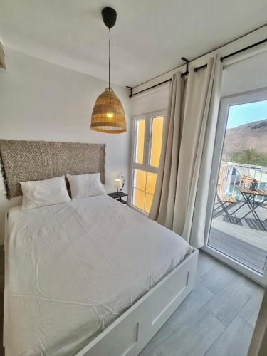 a bedroom with a bed and a large window at Apartamento La Pista Sur in San Sebastián de la Gomera