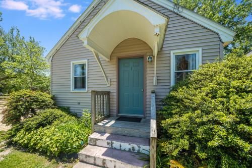 a small house with a blue door and stairs at Chris Cottage 1 in Chincoteague
