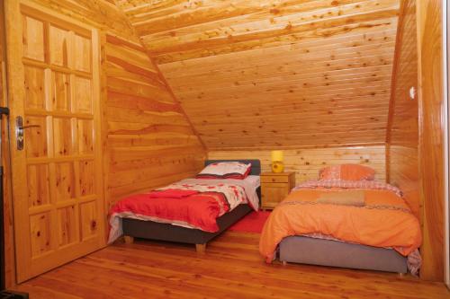 a room with two beds in a log cabin at Domki całoroczne u Greściaków in AdamÃ³w