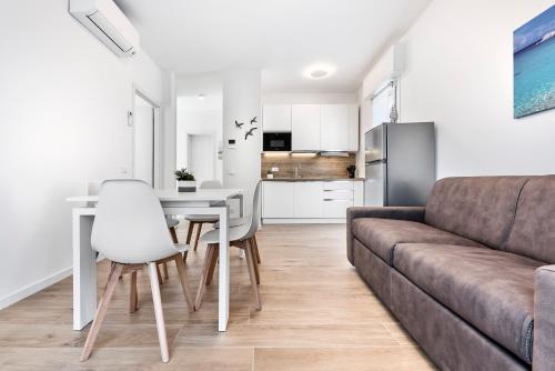 a living room with a couch and a table and chairs at Sand Beach House - Host Solution in Cavallino-Treporti