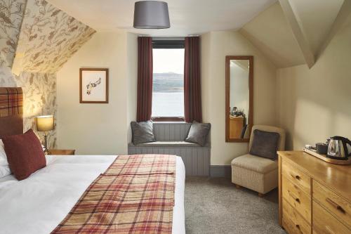 a hotel room with a bed and a chair and a window at Inn at Port nan Gael in Pennyghael