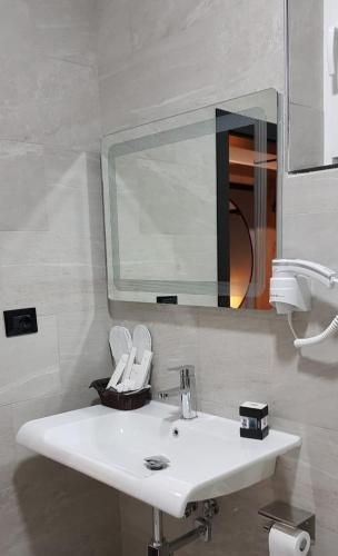 a bathroom with a white sink and a mirror at Eurobushi Hotel in Kolgecaj