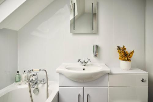 a white bathroom with a sink and a bath tub at Inn at Port nan Gael in Pennyghael