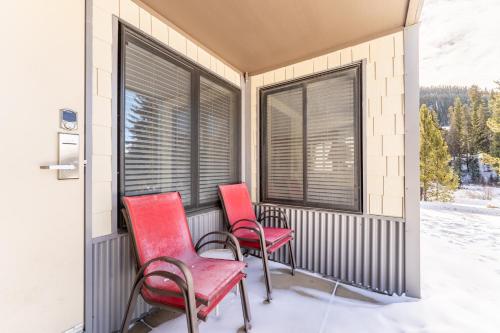 two red chairs sitting on a balcony with windows at Plaza #1404 in Keystone