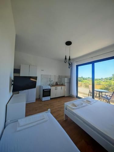 a room with two beds and a kitchen with a view at White apartments in Ulcinj