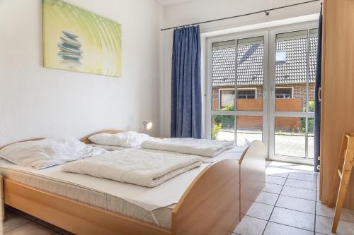 a bedroom with a bed and a large window at 50081... in Carolinensiel