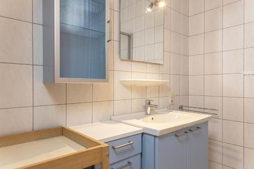 a white bathroom with a sink and a mirror at 50081... in Carolinensiel
