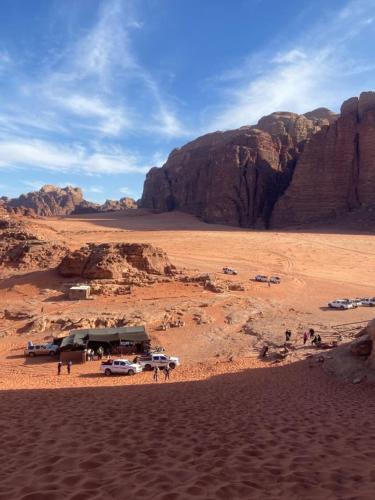 a group of vehicles parked in the desert at وادي رم in Disah