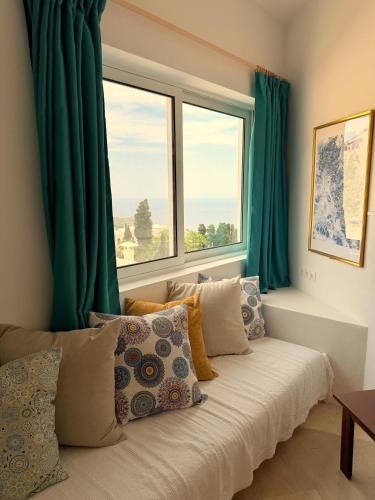 a room with a large window with green curtains at Art & Motion Union - Sunrise Room in Andros