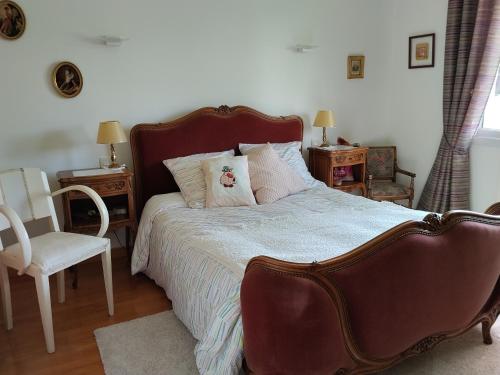 ein Schlafzimmer mit einem Bett, einem Stuhl und zwei Tischen in der Unterkunft Petit Lu in Quincampoix