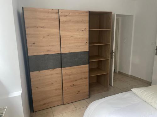 a large wooden cabinet in a bedroom with a bed at Appartement calme et serein in Vals-près-le-Puy