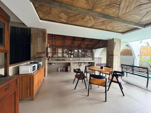 a kitchen with a table and chairs and a counter at Kalpa Tree Co-living in Canggu