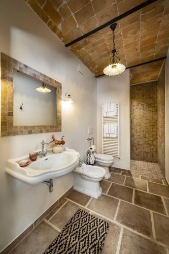a bathroom with a sink and a toilet and a mirror at Casa di Sofia in Calosso