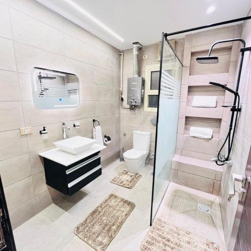 a bathroom with a shower and a sink and a toilet at NOVA GATE Panorama Pyramids Suite in Giza