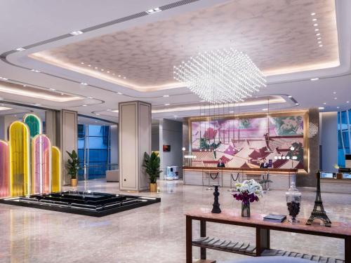 a lobby with a large chandelier in a building at Mercure Beijing Downtown in Beijing