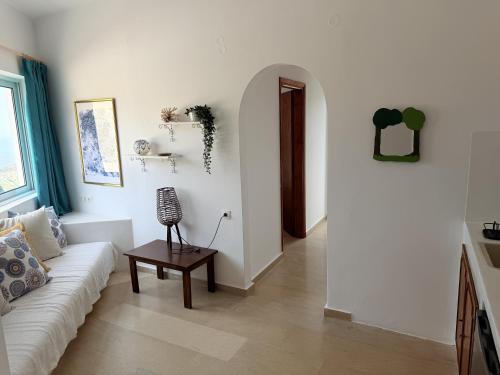 a living room with a white couch and a table at Art & Motion Union - Sunrise Room in Andros