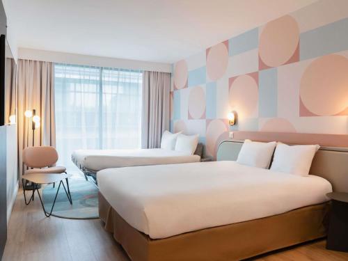 a hotel room with two beds and a large window at ibis Styles Paris Porte d'Orléans in Montrouge