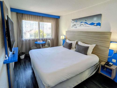 a hotel room with a large bed and a window at ibis Styles Grenoble Centre Gare in Grenoble