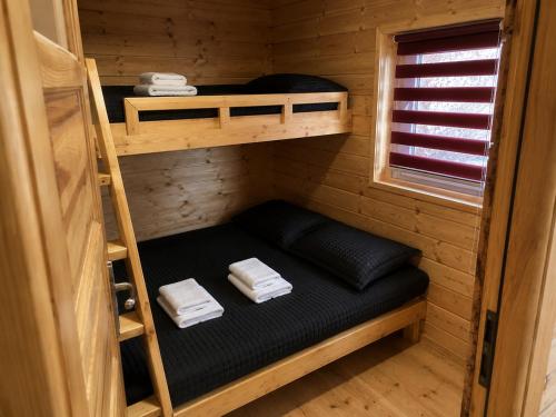 a small room with two bunk beds in a cabin at Domekwroznowiepl in Rożnów