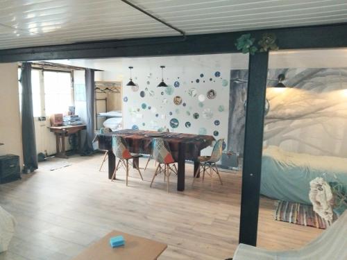 a dining room with a table and chairs in a bedroom at Studio calme avec billard in Saint-Priest