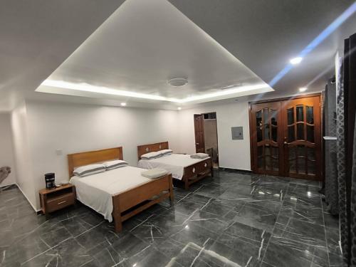 a bedroom with two beds and a ceiling with at Frontera Stay Don Pinto in Canoa Abajo