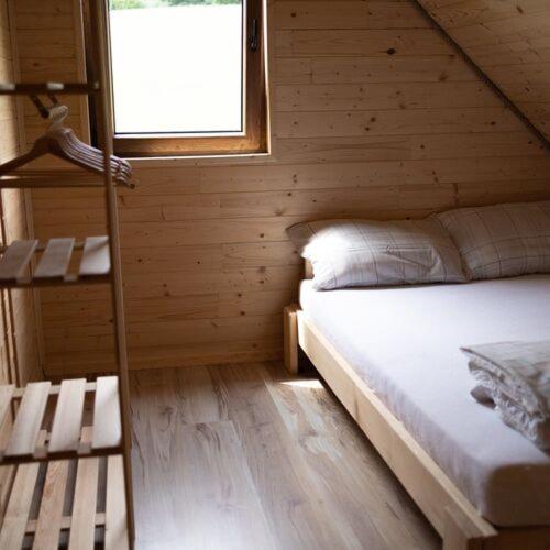 a bedroom with a bed in a log cabin at Domki Lawendowa Skarpa in Zawóz