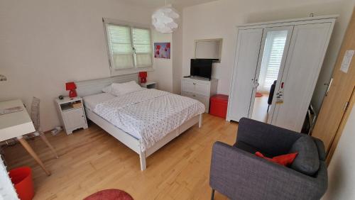 a small bedroom with a bed and a chair at BnB "Les Coquelicots" in Mies