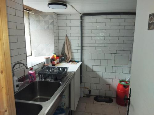 a small kitchen with a sink and a window at Studio calme avec billard in Saint-Priest