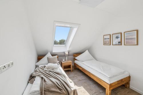 a bedroom with two beds and a window at Ferienwohnung Aquamarin Büsum in Westerdeichstrich