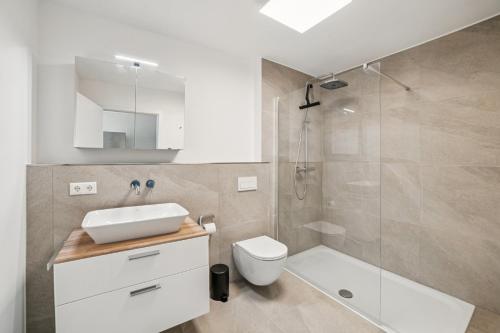 a bathroom with a shower and a toilet and a sink at Ferienwohnung Aquamarin Büsum in Westerdeichstrich