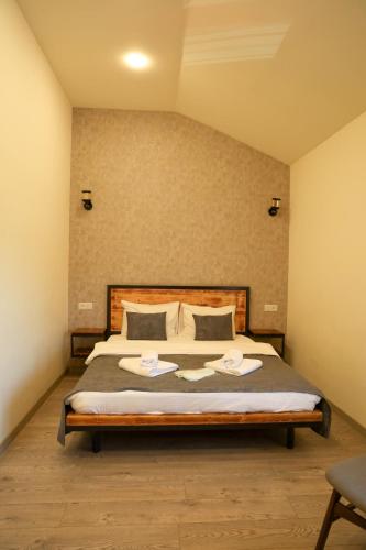 a bedroom with a bed with two towels on it at WaterFall Hotel in Yerevan