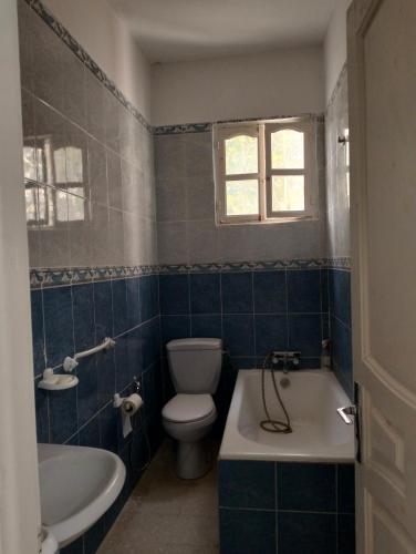 a bathroom with a toilet and a tub and a sink at Maison indépendante pieds dans l'eau in Sousse