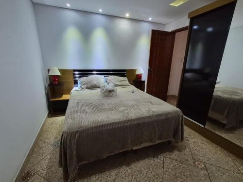 a bedroom with a bed with a cat sitting on it at Flat Região Central 2 in Barbacena
