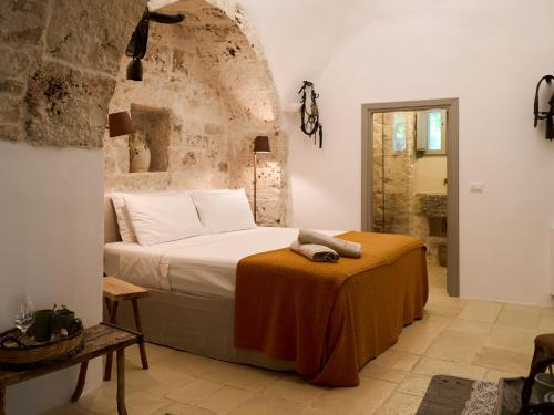 a bedroom with a bed and a table in a room at Dimora Dei Semplici in Ostuni