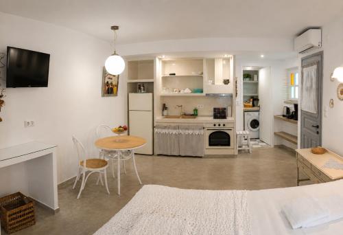 a kitchen and living room with a table and a refrigerator at Est 1852 - Cozy in Andros