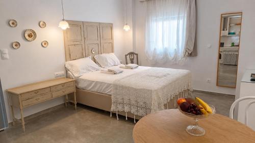 a bedroom with a bed with a bowl of fruit on a table at Est 1852 - Cozy in Andros