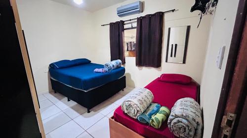 a small room with two beds and a couch at Casa Aconchegante Uberlândia in Uberlândia
