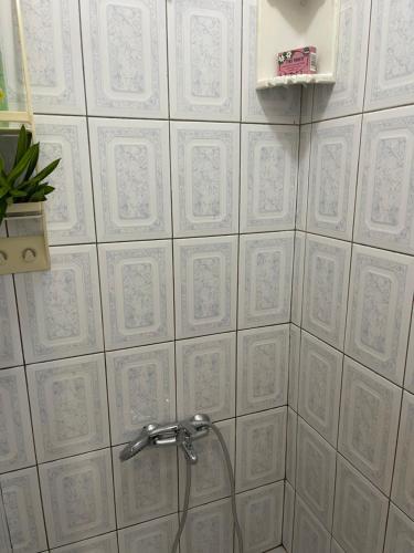 a bathroom with white tiled walls and a shower at NAEHU TEMAUI A MATUANUI Lodge in Tiputa