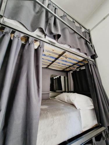 a bunk bed with curtains on top of it at Why Not Nueva Cordoba in Córdoba