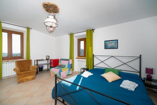a bedroom with a blue bed and a chair at Autenticum Agriturismo Tolfa in Tolfa