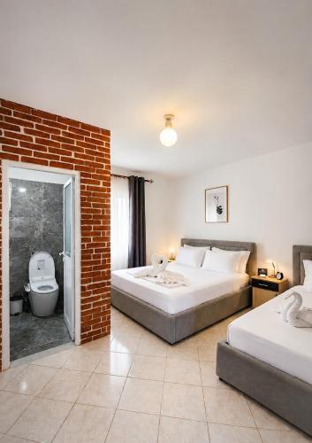 a bedroom with two beds and a brick wall at Villa Murataj in Ksamil