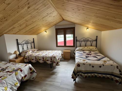 a bedroom with two beds and a wooden ceiling at Casa Bartolo in Vélez-Rubio