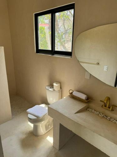 a bathroom with a toilet and a sink and a mirror at La Calita de Teques in Tequesquitengo