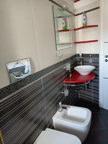 a bathroom with a white toilet and a sink at La RIVISTA in Manduria